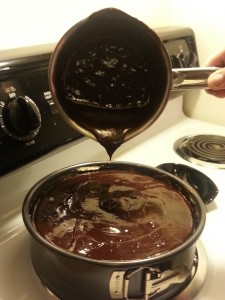 Pouring the chocolate layer over the OREO Cheesecake 