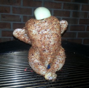 Beer Can Chicken on the grill with onion stuffed in the top. 