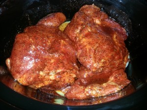 Place each half of the pork shoulder on the bottom of the slow cooker.